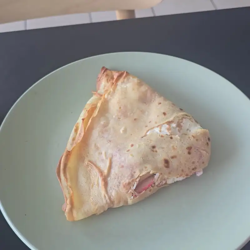 Kawałek naleśnika na miętowym talerzu